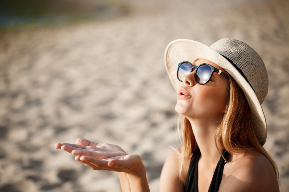 Une femme sur la plage avec des lunettes de soleil