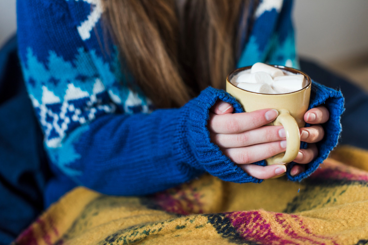 Une femme tient une boisson chaude