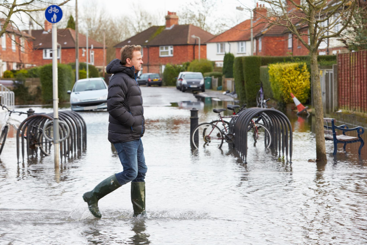 Un homme marche dans une rue inondée