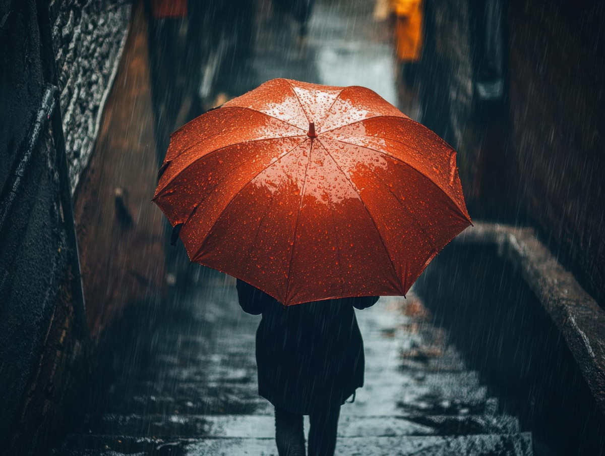 Une femme tient un parapluie rouge