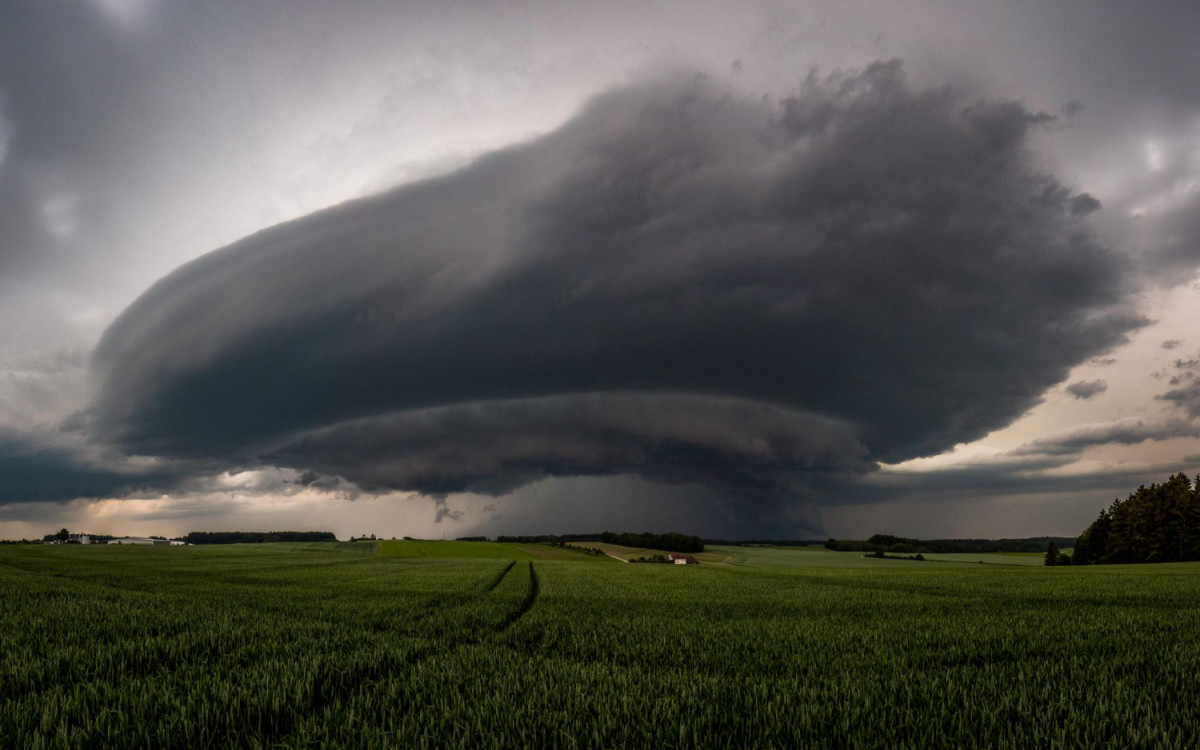 Des nuages très noirs s'amoncèlent au-dessus d'une plaine