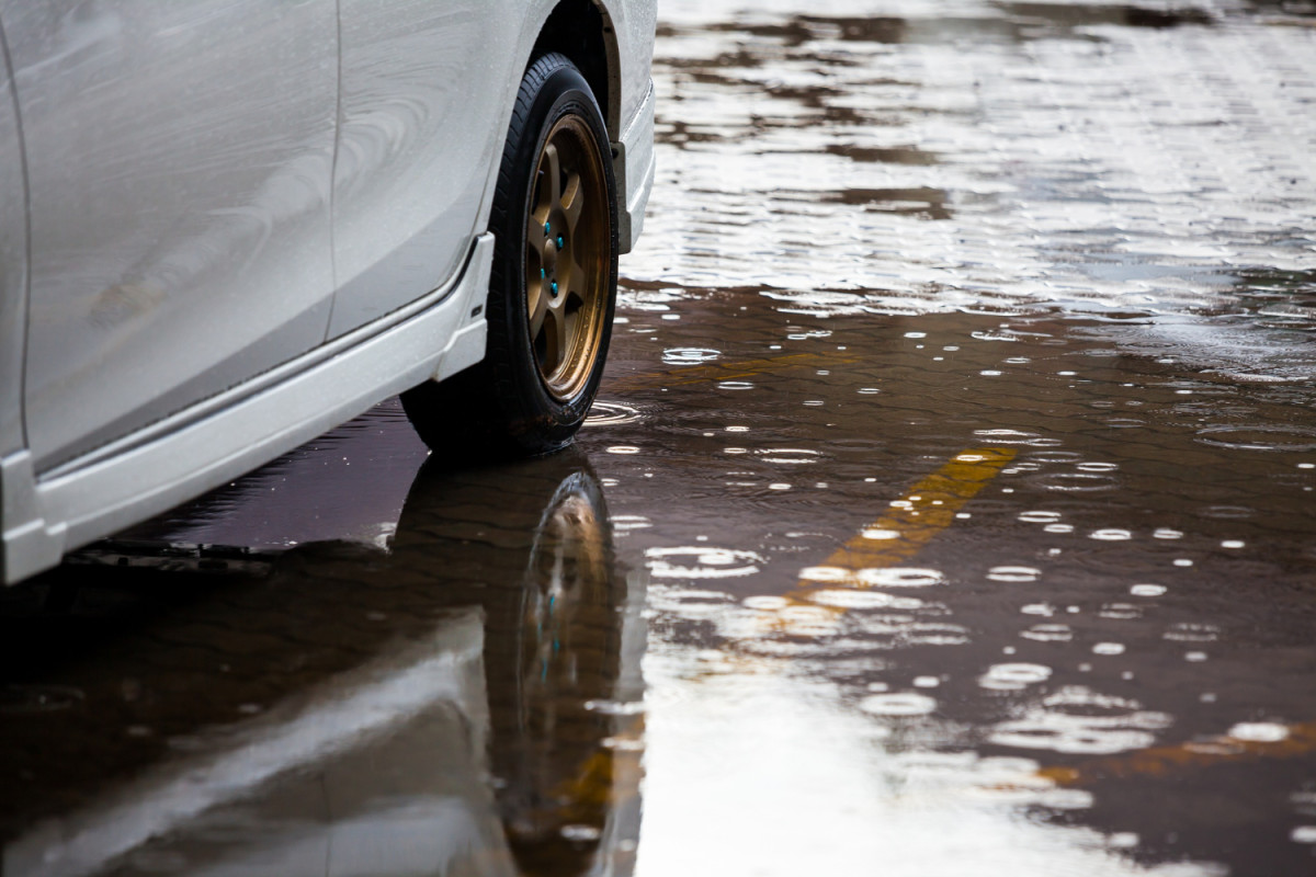 Une voiture roule dans une flaque d'eau