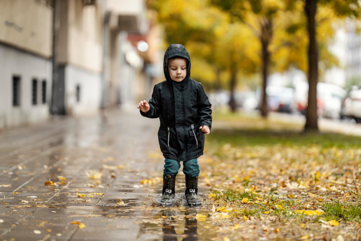 Un enfant debout sous la pluie en ville