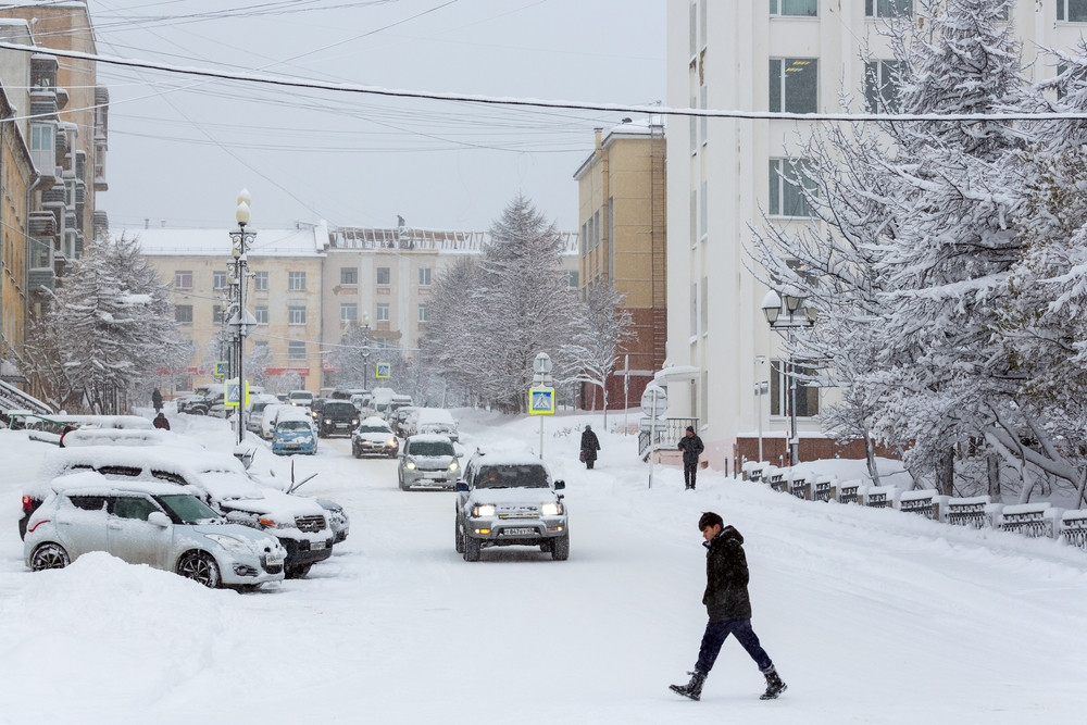 Un homme marche dans une rue enneigée