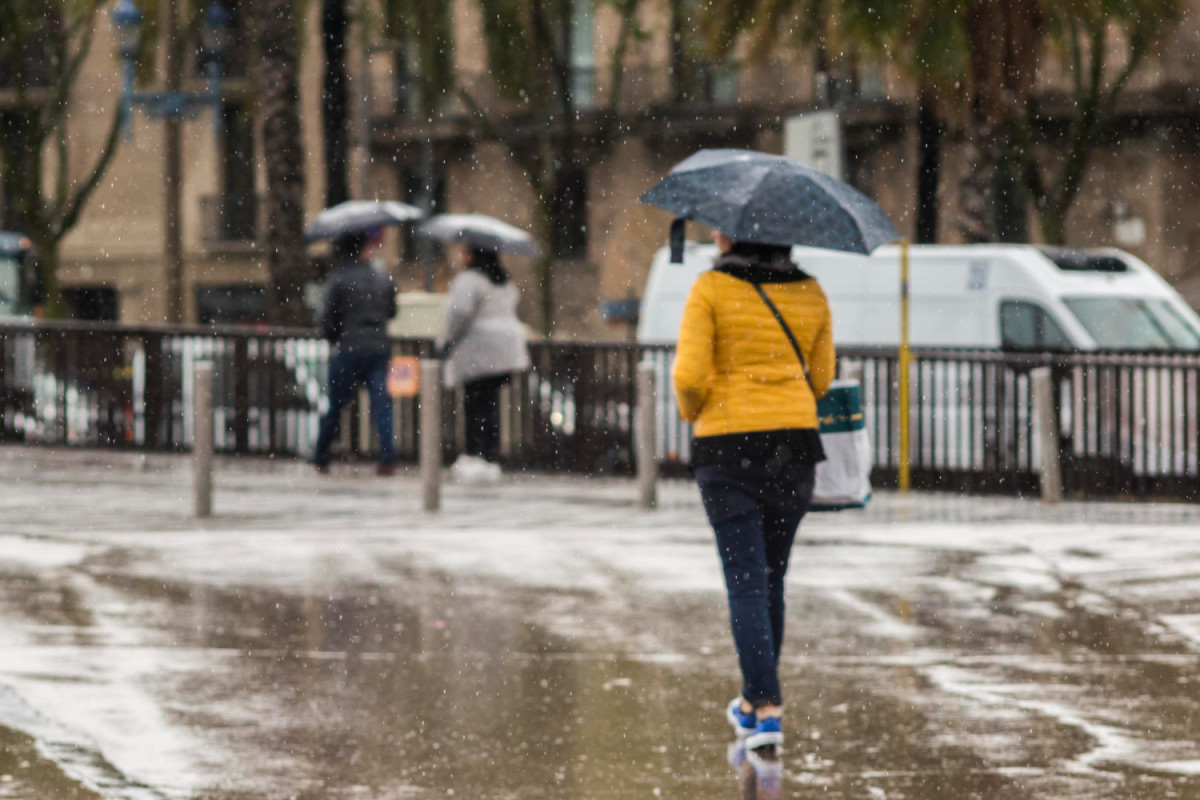 Une femme marche sous la pluie dans la rue