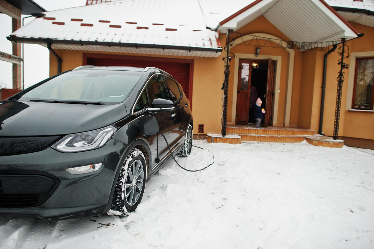 Une voiture électrique branchée en hiver