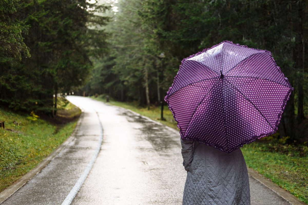 Une femme marche sous la pluie avec un parapluie
