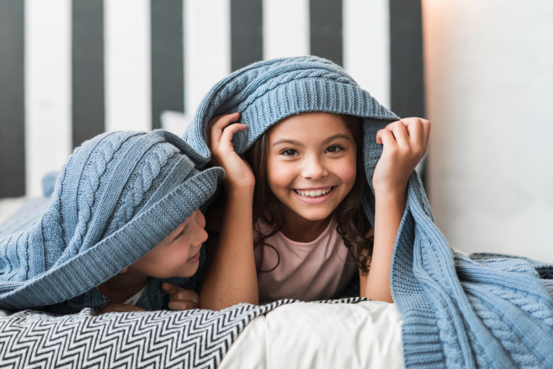 Des enfants sous une couverture