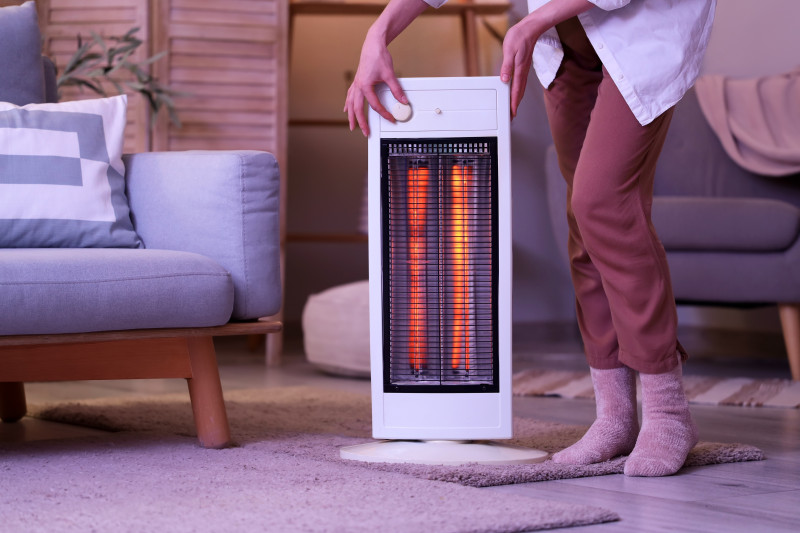 Une femme allume un chauffage