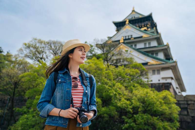 Une touriste devant le chateau d'Osaka au Japon