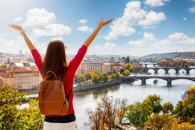 Une femme lève les bras en l'air face à un beau paysage