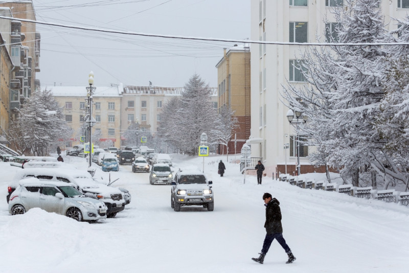 Un homme marche dans une rue enneigée