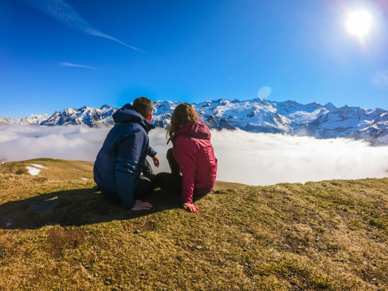Un couple observe le soleil sur une montagne