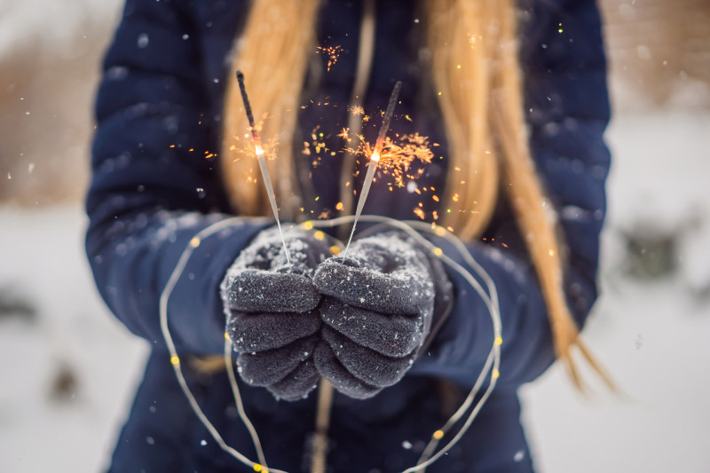 Une femme tient un feu d'artifice dans sa main