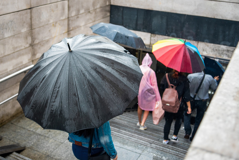 Des gens descendent un escalier sous la pluie