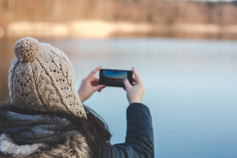 Femme qui prend en photo un lac