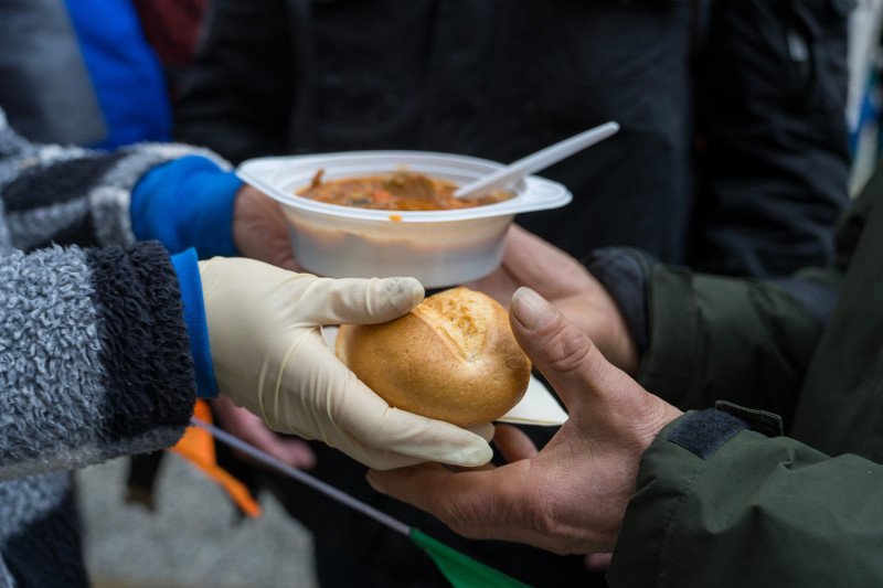 Une personne tend un pain à une autre
