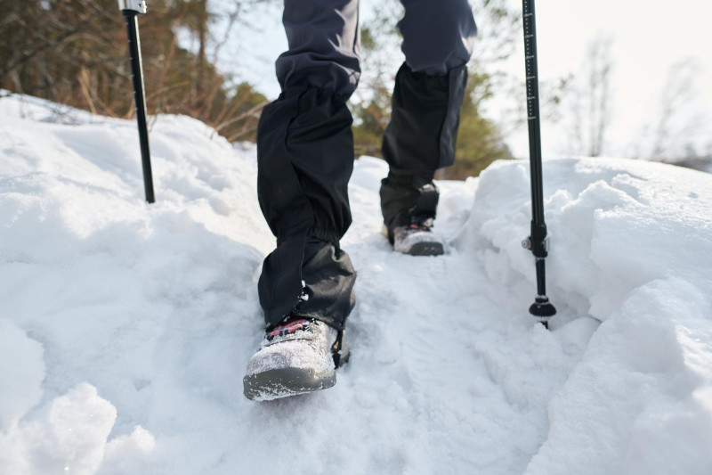 Zoom sur les pieds de quelqu'un qui fait de la randonnée dans la neige