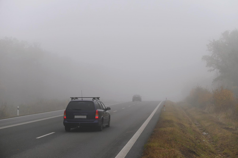 Une voiture roule dans le brouillard
