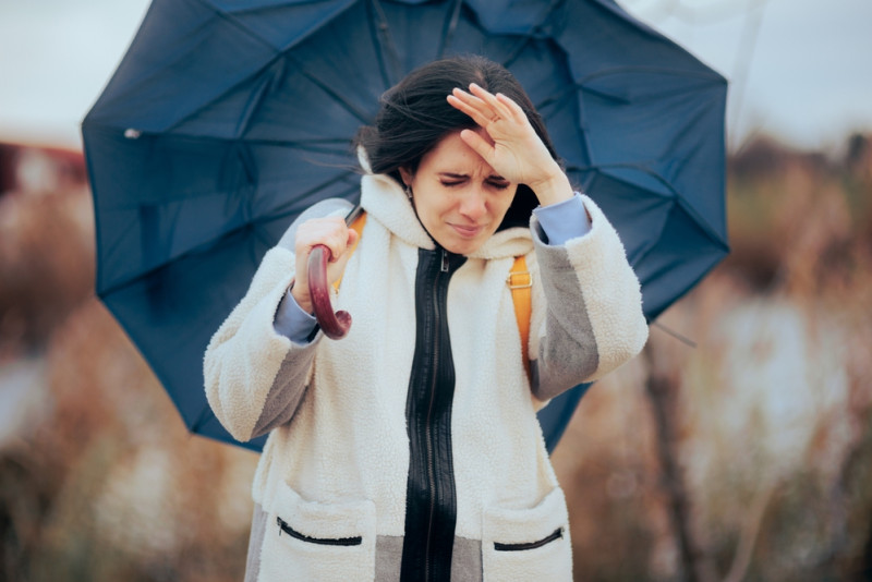 Femme face au vent avec son parapluie