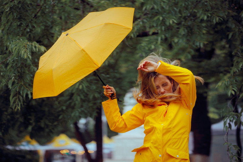 Une femme avec un parapluie emportée par le vent