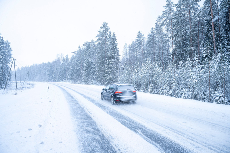 Voiture qui roule sur une rue enneigée