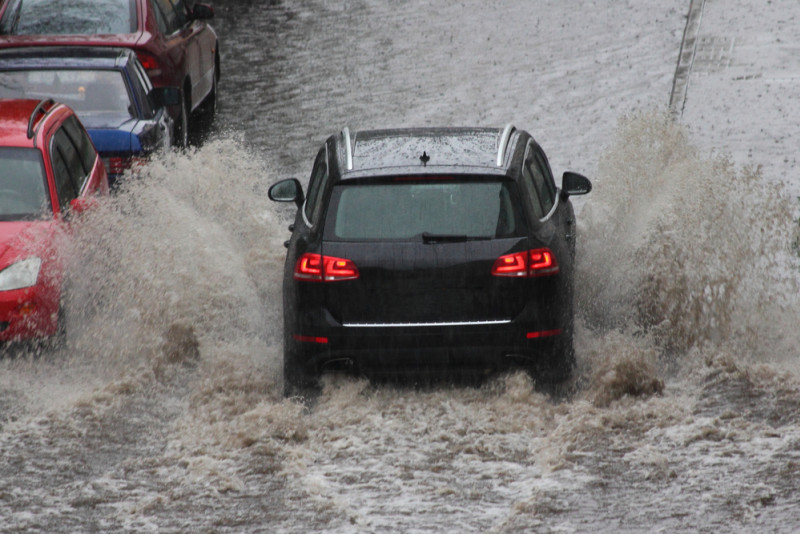 Voiture qui roule dans une rue inondée