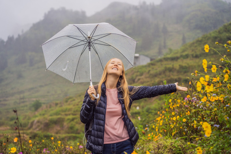 Une femme sous la pluie semble heureuse