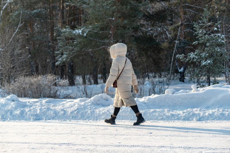Une femme marche dans la neige