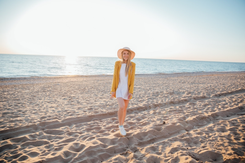 Une femme avec une veste et un chapeau sur une plage
