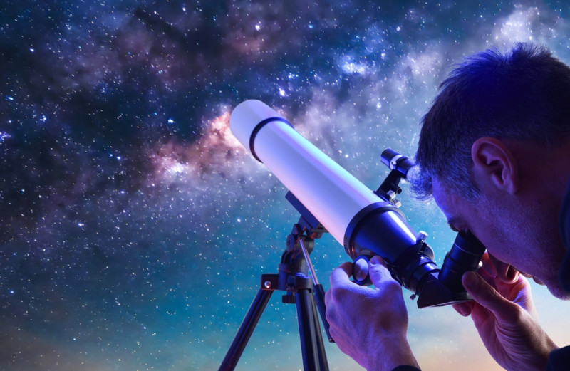 Un homme observe les étoiles avec son télescope