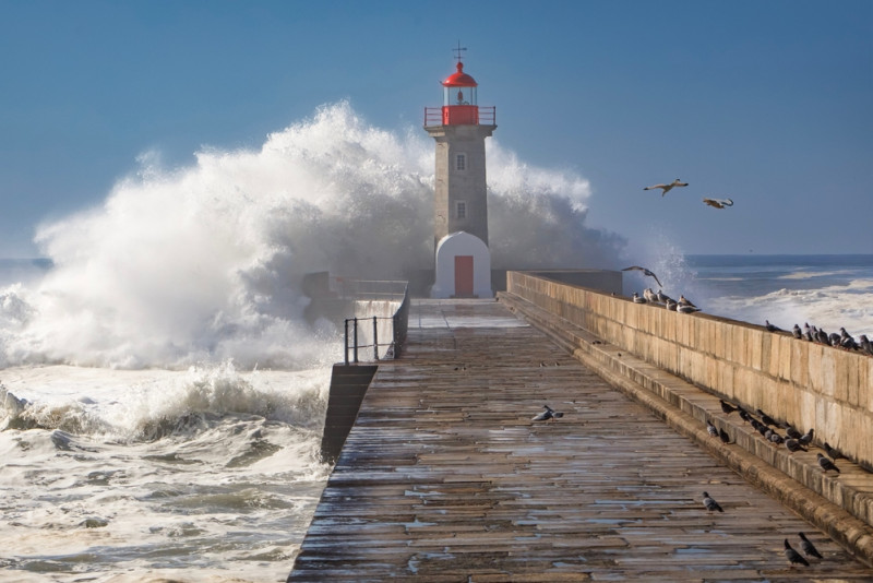 Une vague s'écrase sur un phare