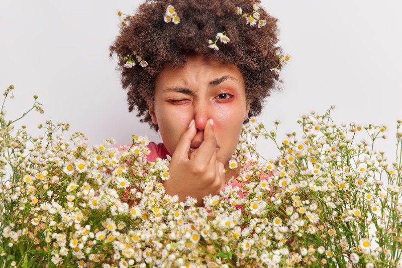 Une femme éternue à cause du pollen