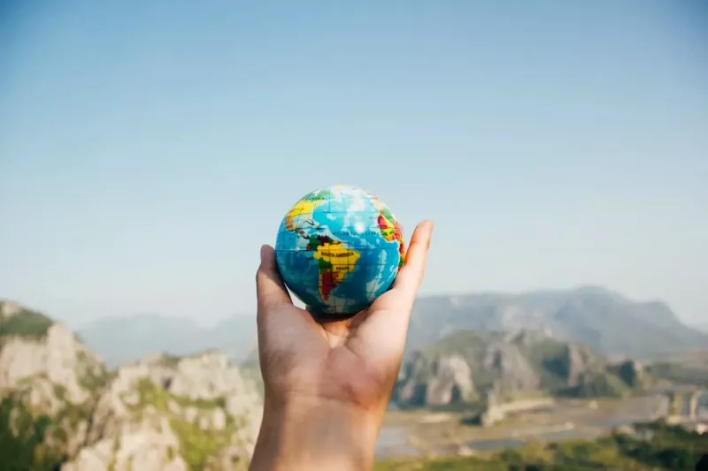 une main tient un globe terrestre
