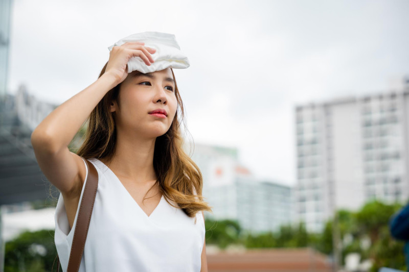 Une femme asiatique s'essuie le front
