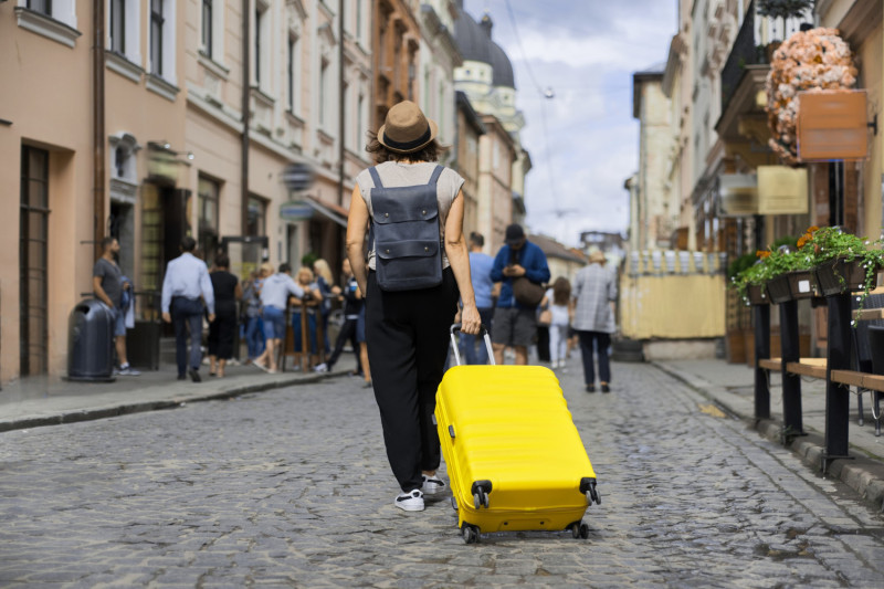 Une femme tire une valise jaune