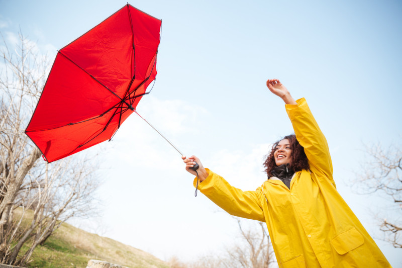 Une femme avec un parapluie qui s'envole dans le vent