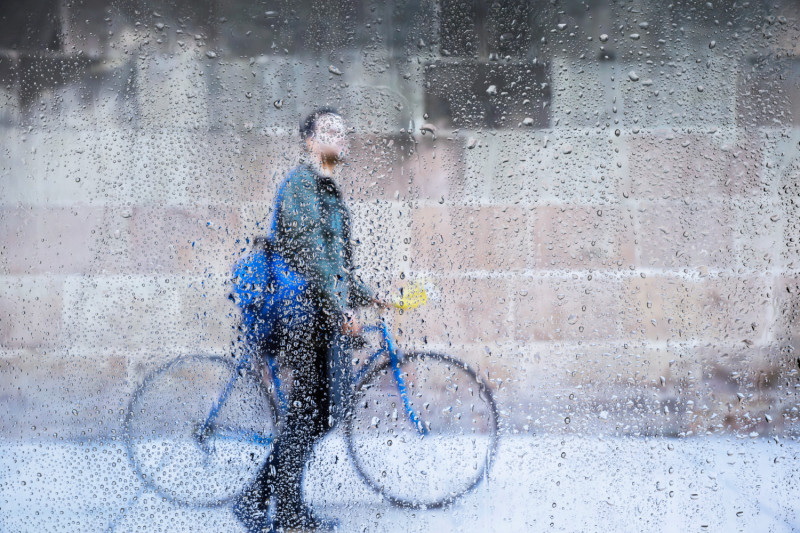 Un homme à vélo sous la pluie