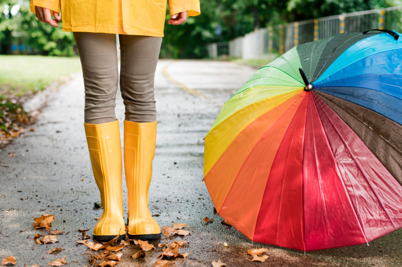 Une femme se tient debout près d'un parapluie ouvert