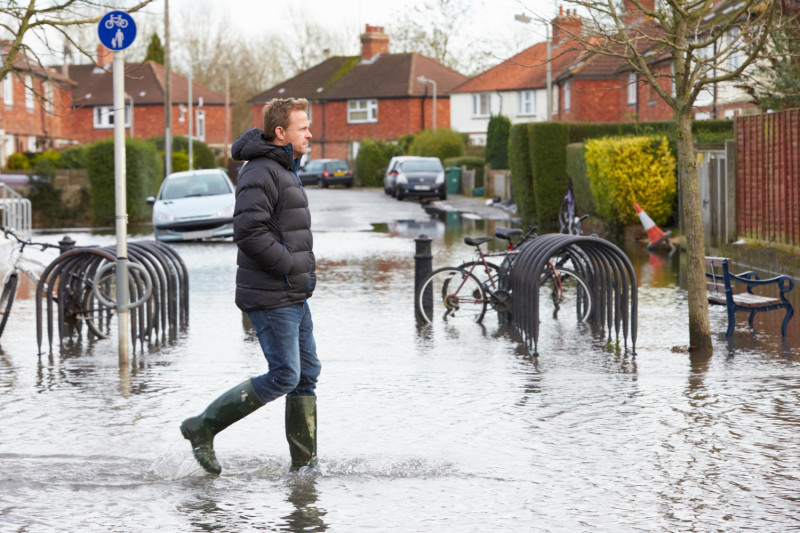 Un homme marche dans une rue inondée