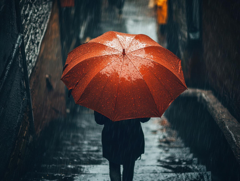 Une femme tient un parapluie rouge