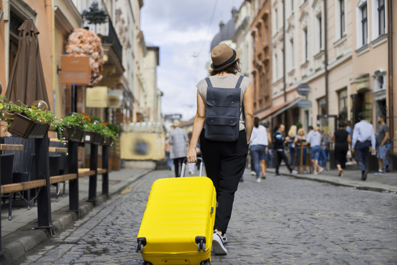 Une femme tire une valise dans une rue