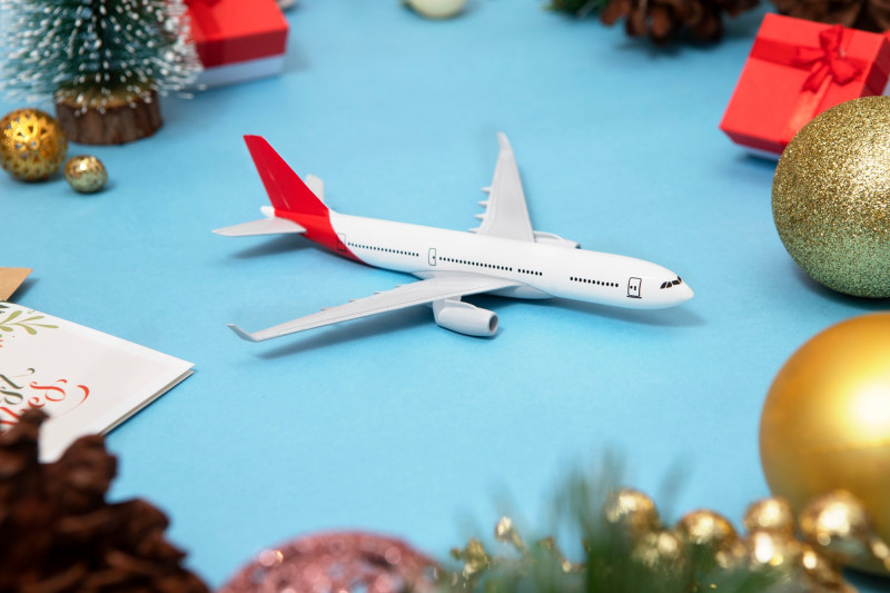 Un avion miniature posé entre des boules de Noël