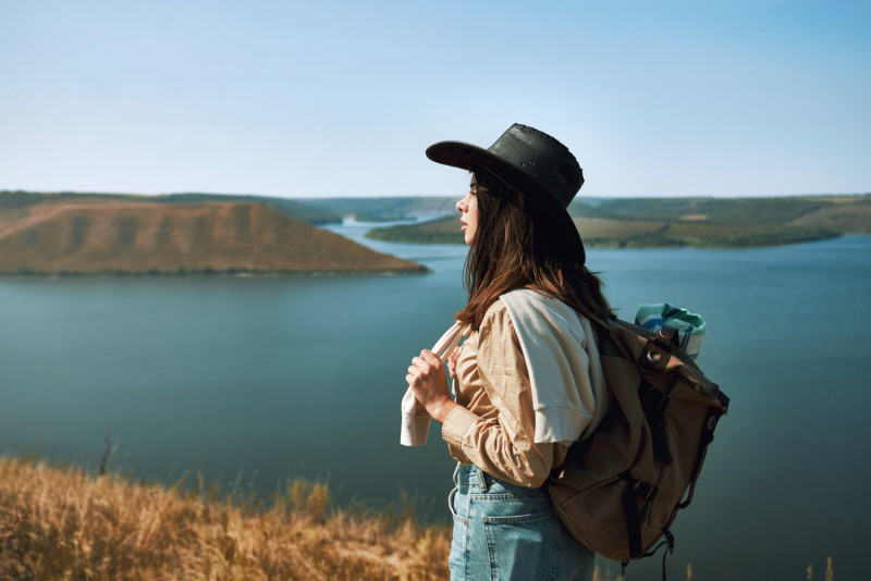 Une femme debout devant un lac