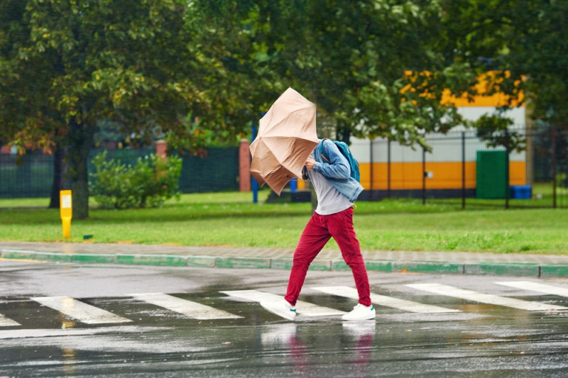 Un homme avec un parapluie lutte contre le vent