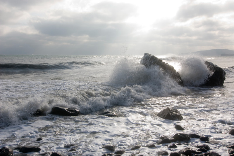 Une vague s'écrase sur un rocher en mer