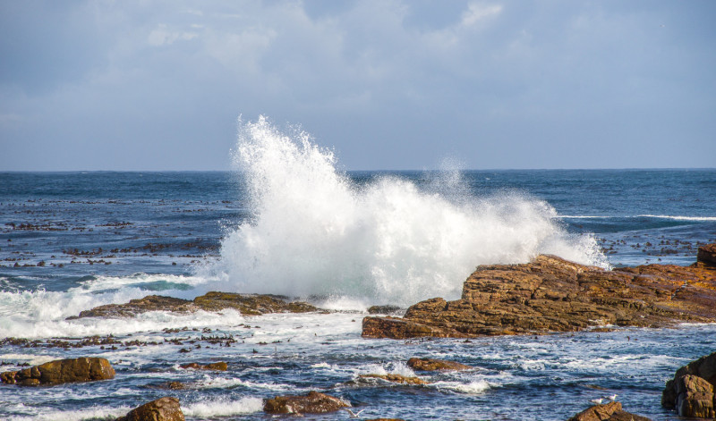 Une vague s'écrase sur un rocher en mer