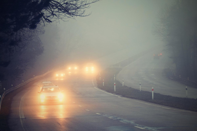 Des voitures roulent dans le brouillard