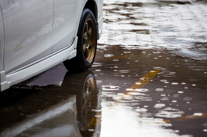 Une voiture roule dans une flaque d'eau