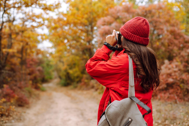 Une femme prend des photos en automne